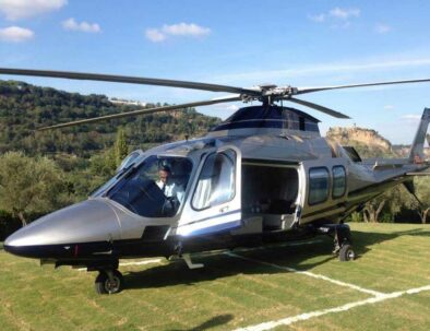 helicopter AW109 Grand-silver colour on helipad in Tuscany - travel services by Timeless Tuscany tour operator