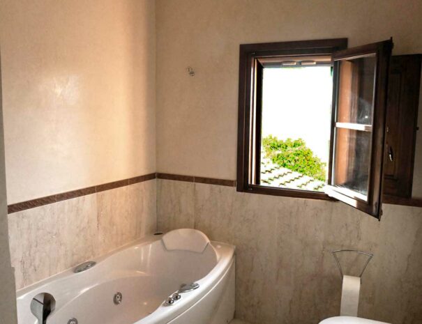 Italy Villa Bellavista Certaldo Chianti; bathroom with tub, bidet and wc; open window overlooking trees and garden - villa rentals by Timeless Tuscany tour operator