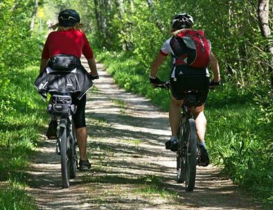 two cyclists riding mountain bike and ebike pedaling on a track in wood - travel experience by Timeless Tuscany tour operator