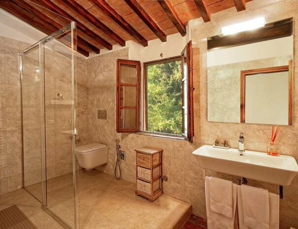 Italy Villa Bellavista Certaldo Chianti; bathroom sink and wc; open window overlooking trees and garden; wooden beams ceiling - villa rentals by Timeless Tuscany tour operator