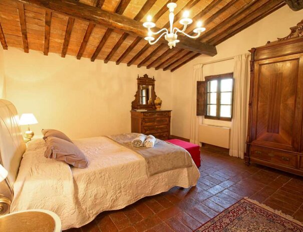 Italy Villa Bellavista Certaldo Chianti; king size bedroom with chest; window and chandelier - villa rentals by Timeless Tuscany tour operator