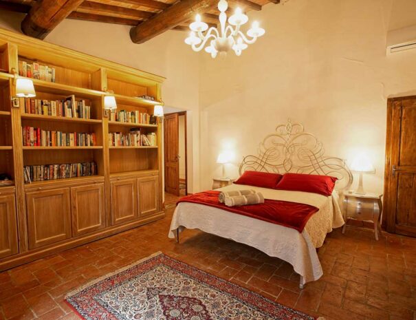 Italy Villa Bellavista Certaldo Chianti; king size bedroom with bookcase and chandelier - villa rentals by Timeless Tuscany tour operator