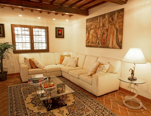 Italy Villa Bellavista Certaldo Chianti; living room with white sofa and window; coffee table, persian carpet; antique lamp and paintings - villa rentals by Timeless Tuscany tour operator