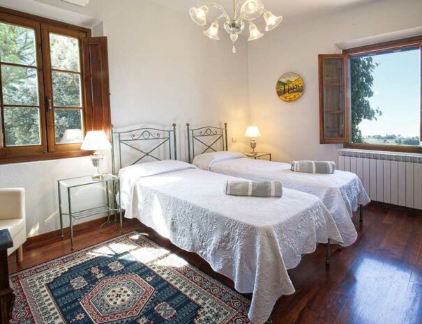 Italy Villa Bellavista Certaldo Chianti; twin beds bedroom with windows and chandelier- villa rentals by Timeless Tuscany tour operator