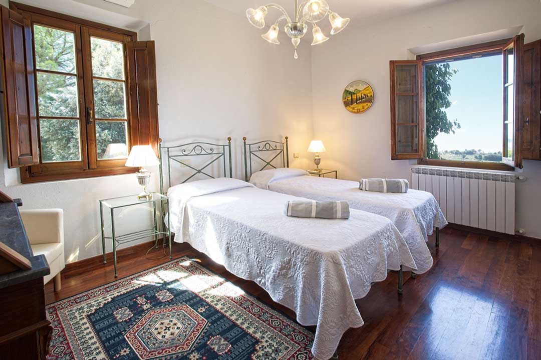 Italy Villa Bellavista Certaldo Chianti; twin beds bedroom with windows and chandelier- villa rentals by Timeless Tuscany tour operator