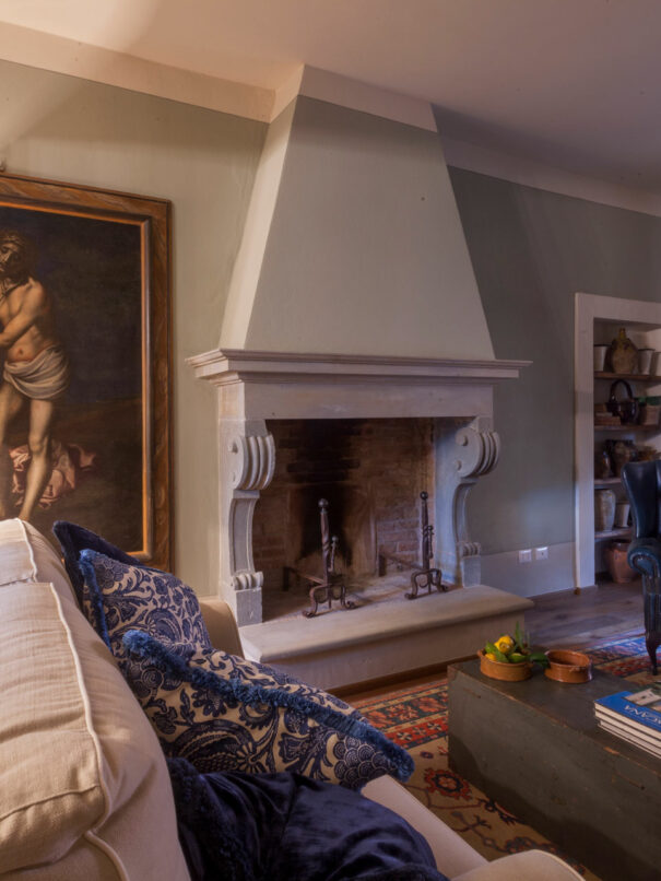 Villa dei Fiori living room with sofa, table lamp and chimney - by Timeless Tuscany villas rentals